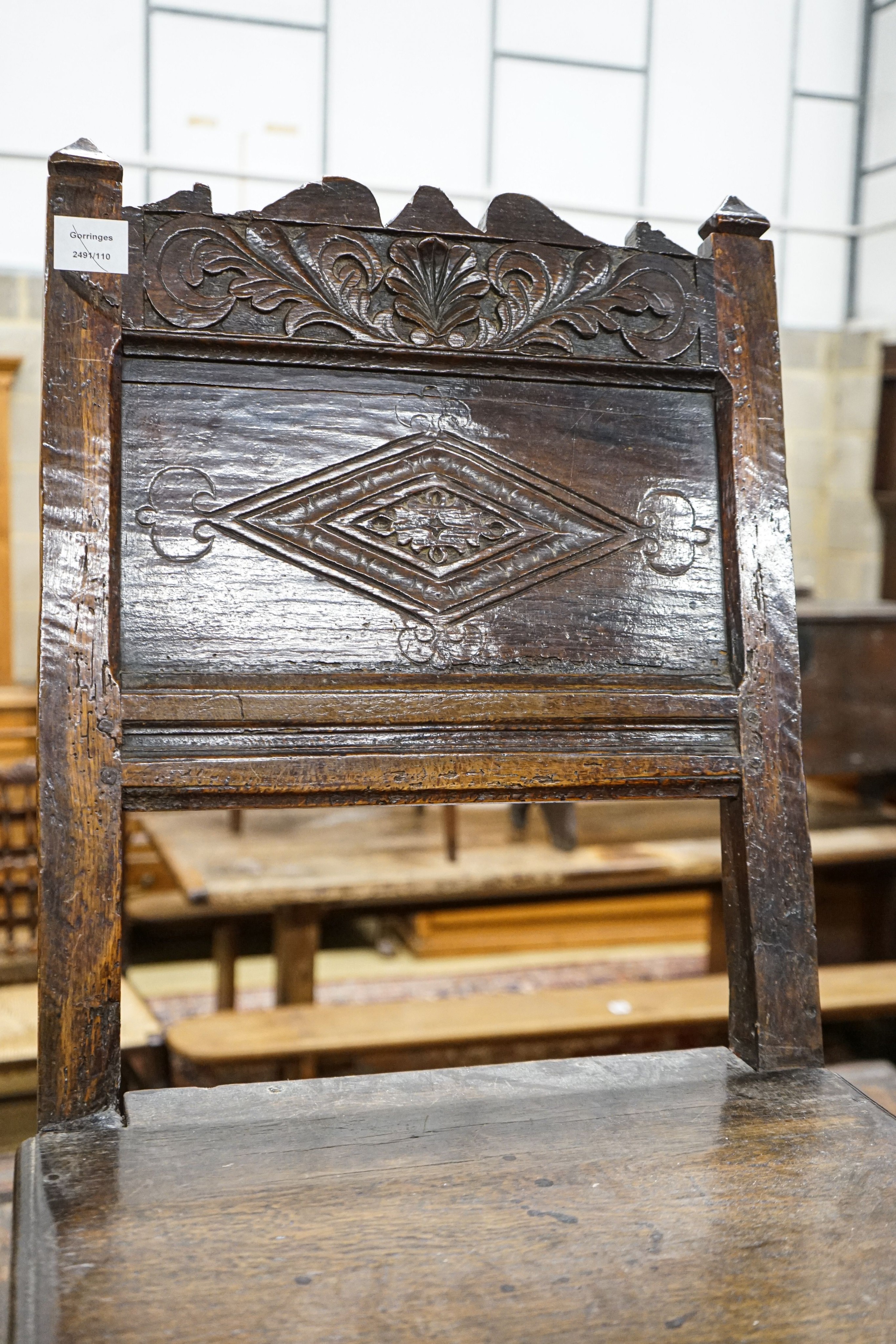 A 17th century oak back stool, with lozenge and foliate carved panelled back and solid seat, on turned and square underframe, width 48cm, depth 40cm, height 97cm, with receipt from Swan Antiques dated 2002